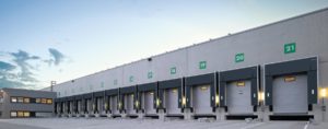 Lagerhalle mit mehreren Garagen für Lastwagen, um Fracht abzusetzen oder zu holen, zeigt die Funktionalität und Effizienz unserer Anlagen
