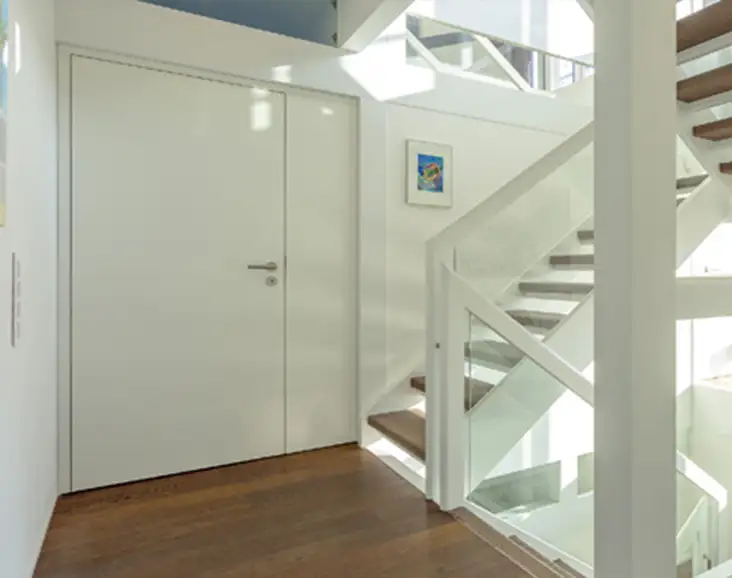 Moderne weiße Innentür von Almtor, nahtlos integriert in ein helles, zeitgenössisches Wohnambiente